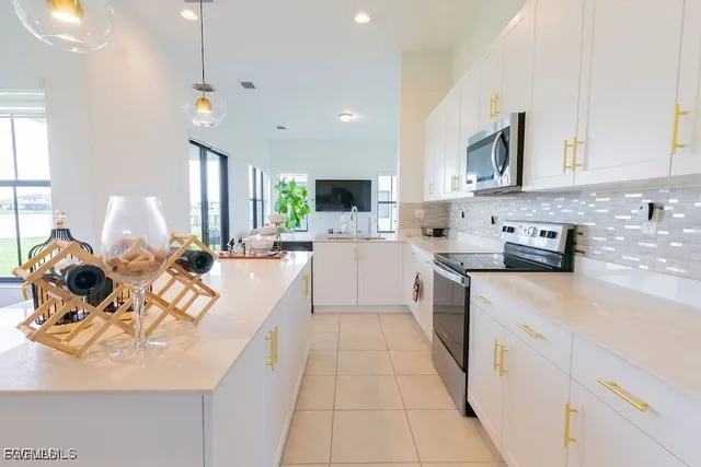 a large kitchen with stainless steel appliances lots of counter space a sink a window and cabinets