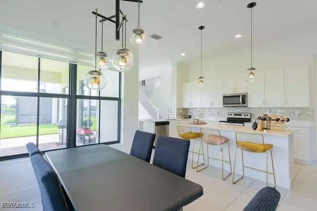 a living room with furniture a chandelier and a flat screen tv