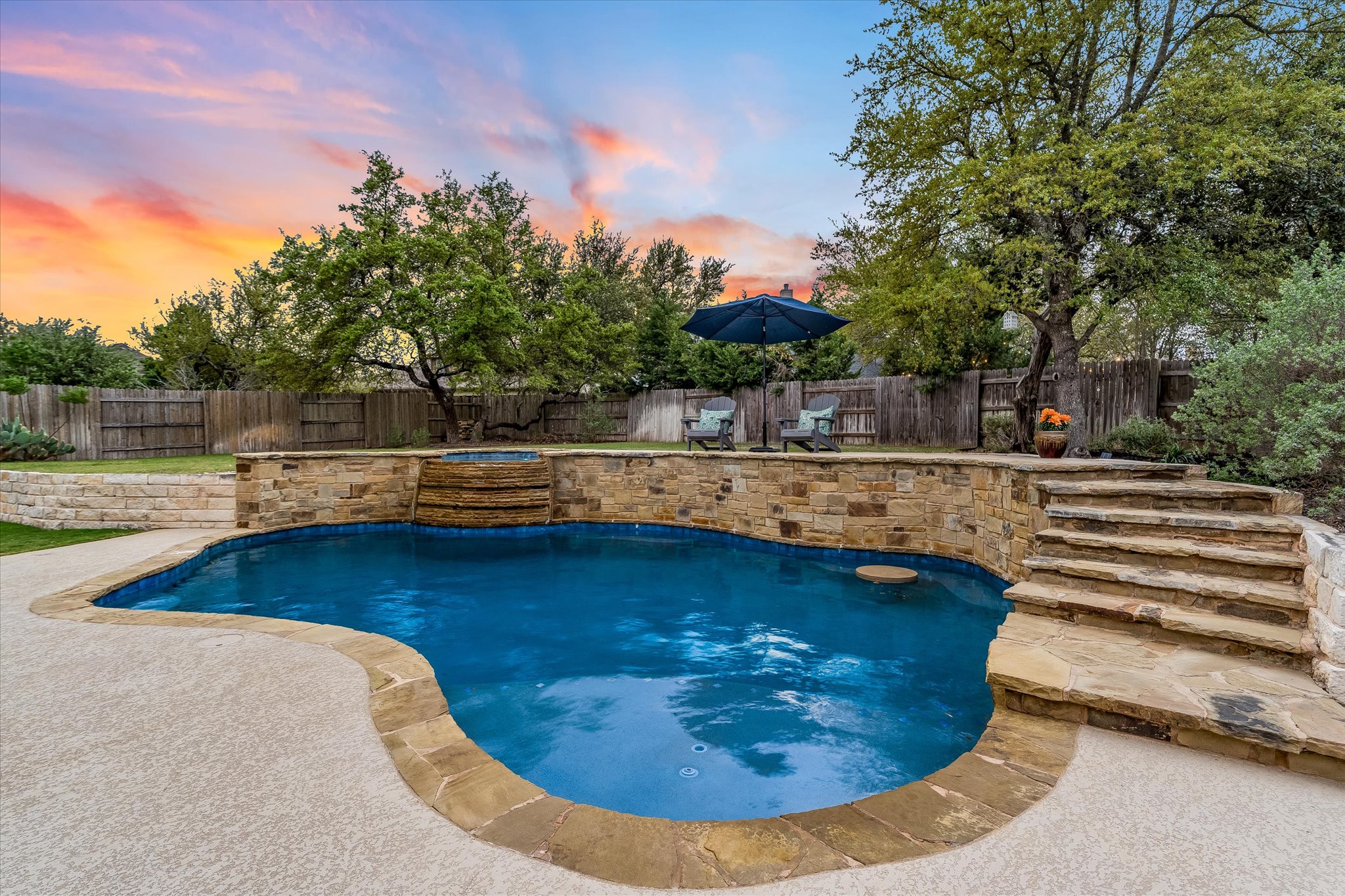 226 Galloway Lane Austin, TX 78737 - Photo 1 of 30 Pool at dusk with a fenced backyard, a patio, and a pool with connected hot tub