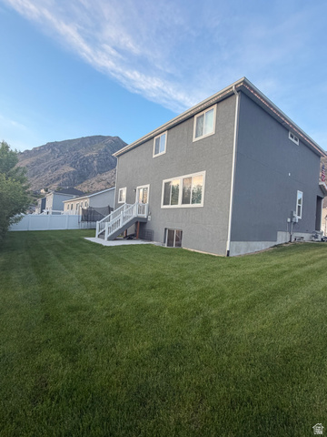 437 North 650 E Street Springville, UT 84663 - Photo 2 of 11 Expansive green lawn with a white vinyl fence and mountain backdrop