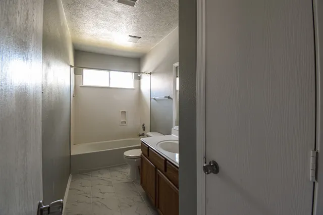 a bathroom with a double vanity sink a toilet and shower
