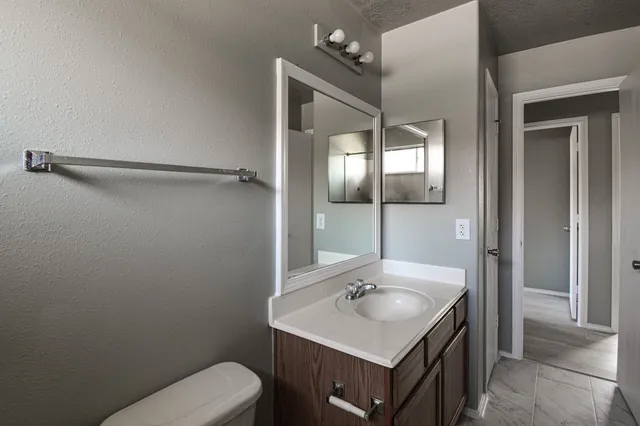 a bathroom with a toilet sink and mirror
