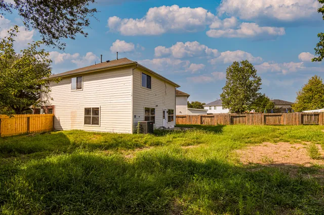 a view of backyard of house and trees in the background