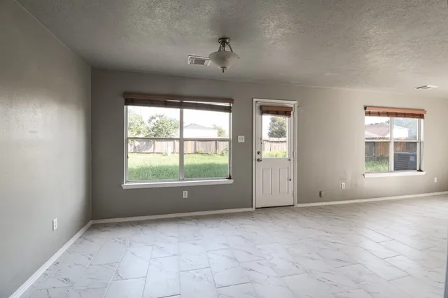 an empty room with windows and closet