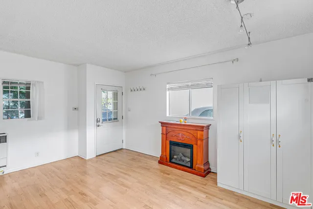 a view of empty room with a fireplace and wooden floor
