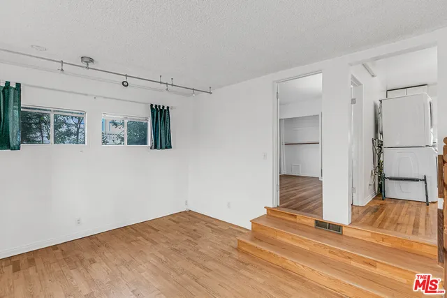 a view of a bedroom with wooden floor and a bed