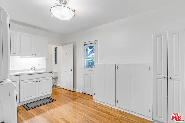 a kitchen with a sink cabinets and wooden floor