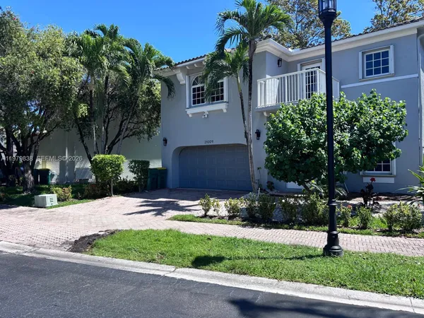 a front view of a house with a yard and potted plants