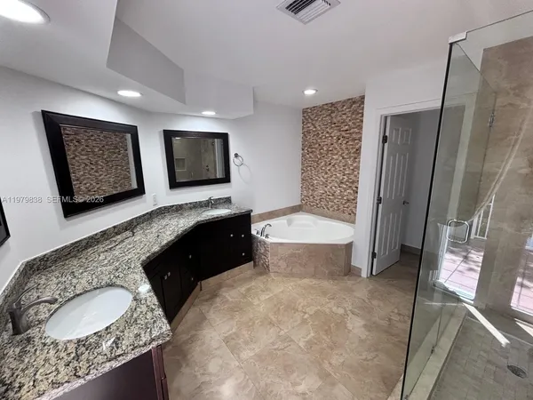 a spacious bathroom with a granite countertop sink and a mirror