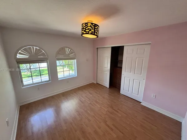 an empty room with windows and wooden floor