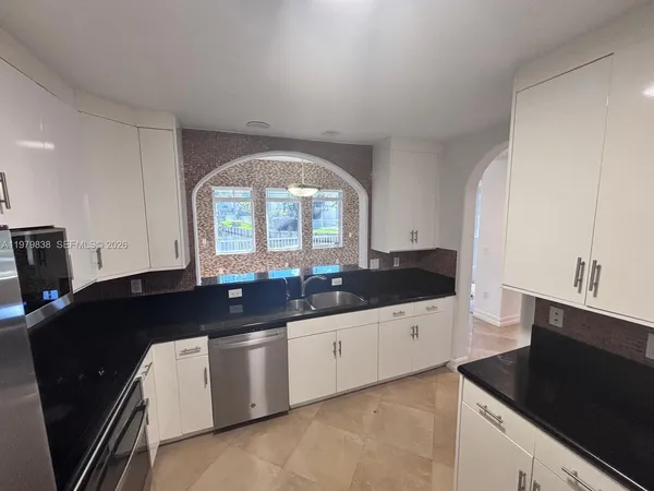 a kitchen with granite countertop a sink and a stove top oven