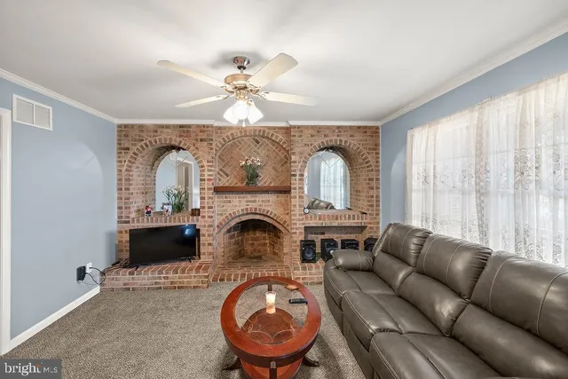 a living room with furniture a fireplace and a chandelier