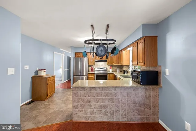 a kitchen with a sink cabinets stainless steel appliances and a large window