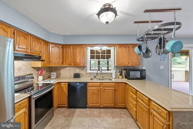 a view of a room with wooden floor a fireplace and windows