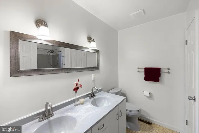 a bathroom with a granite countertop toilet sink and mirror