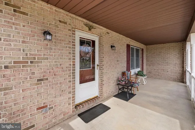 a view of a porch with wooden floor next to a yard