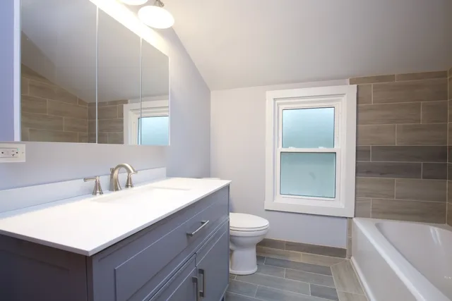 a bathroom with a sink toilet vanity and bathtub