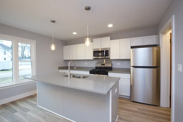 a kitchen with stainless steel appliances a refrigerator sink and microwave