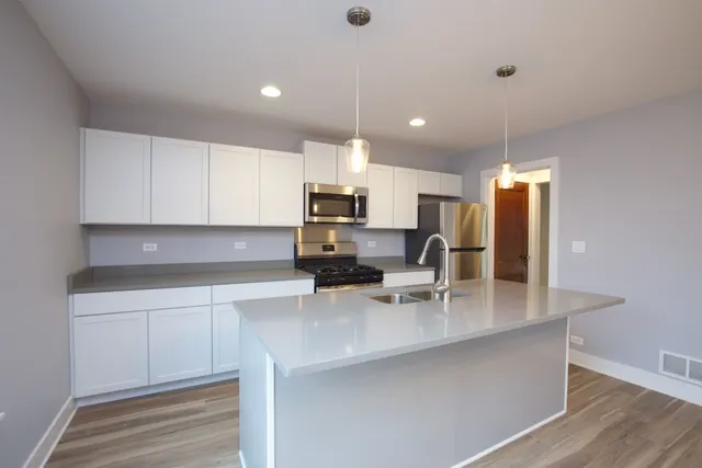 a kitchen with kitchen island a sink appliances and cabinets