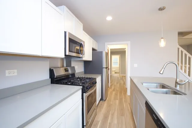 a kitchen with sink a stove and cabinets