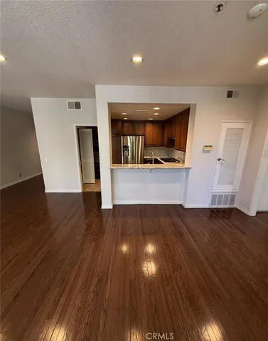 a view of a living room a wooden floor and cabinets