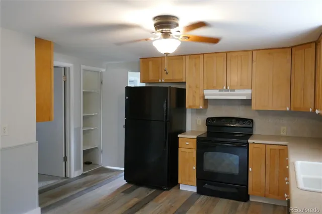 a kitchen with a refrigerator and a stove top oven