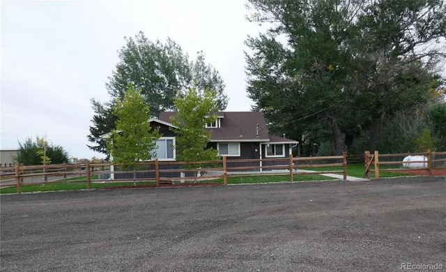 a view of a house with backyard and a tree