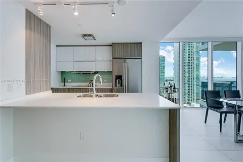 a room with kitchen island a sink and a large window