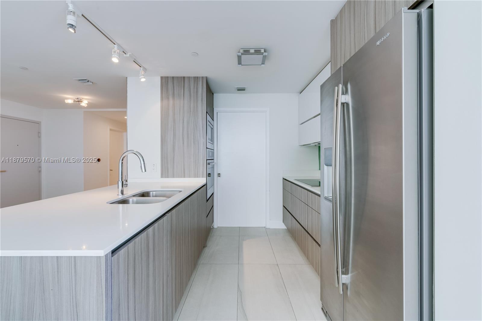 600 Northeast 27th Street, Unit 2801 Miami, FL 33137 - Photo 21 of 48 a kitchen with granite countertop a sink and refrigerator