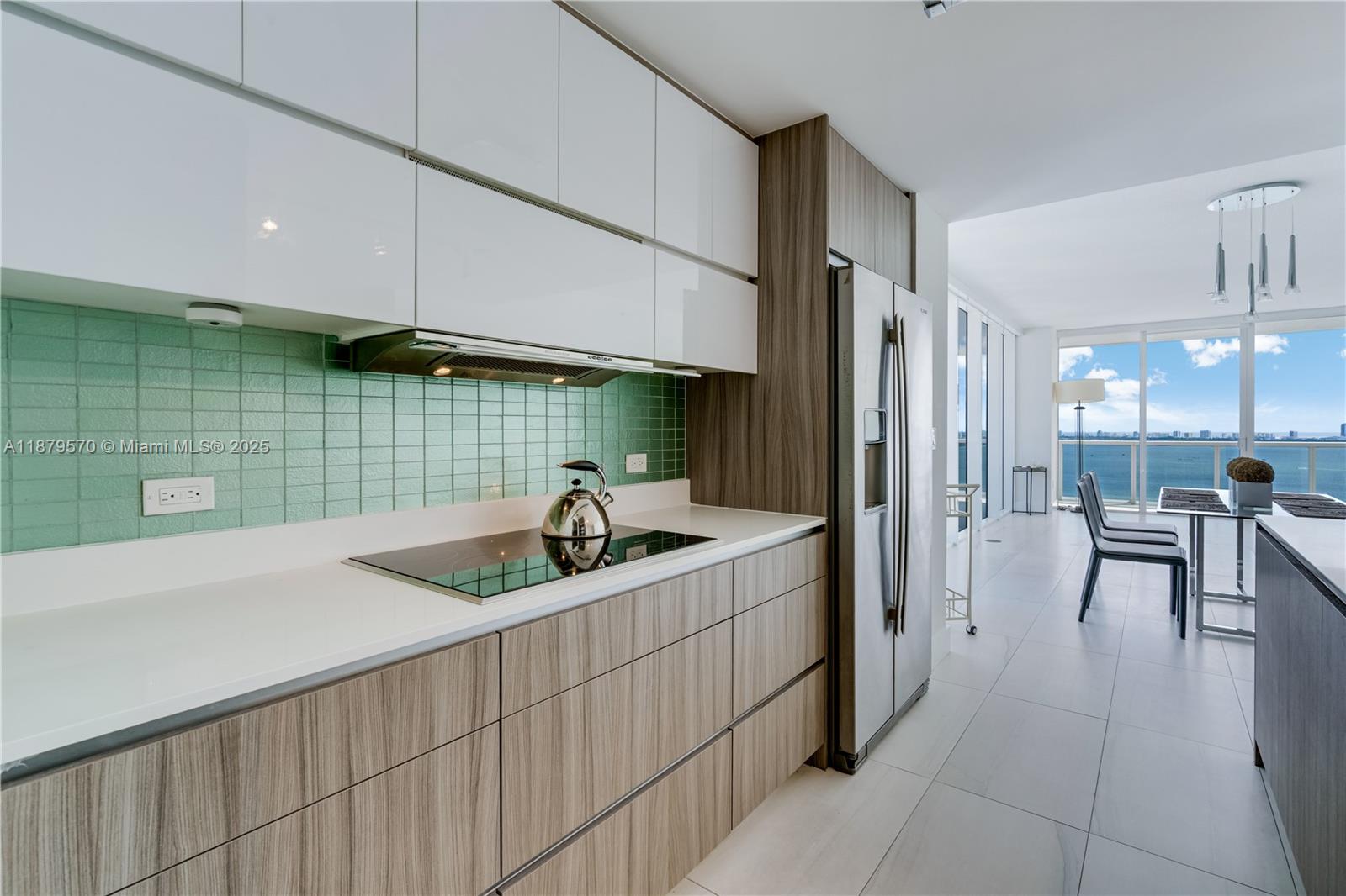 600 Northeast 27th Street, Unit 2801 Miami, FL 33137 - Photo 22 of 48 a kitchen with a sink a refrigerator and chairs