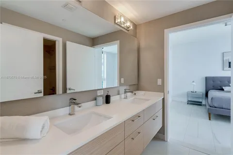 a bathroom with double vanity sinks and a mirror