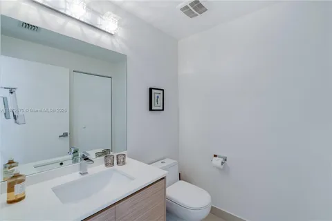 a bathroom with a sink mirror vanity and toilet