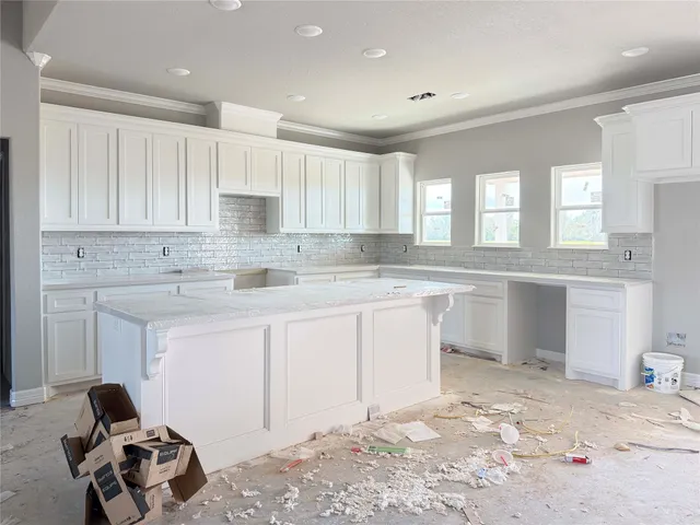 a kitchen with granite countertop a sink cabinets and window