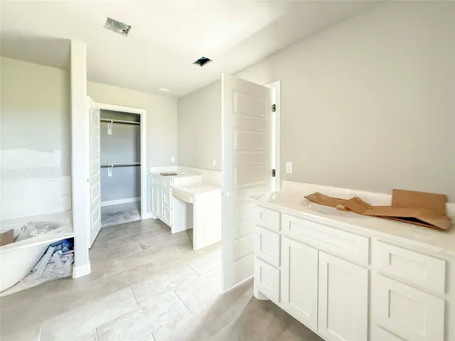 a spacious bathroom with a granite countertop sink and a mirror