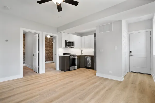 a view of kitchen with stainless steel appliances kitchen island hardwood floor and a sink