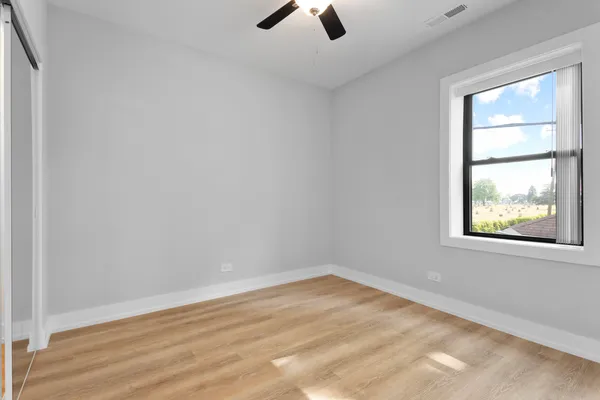 an empty room with a window and a ceiling fan view