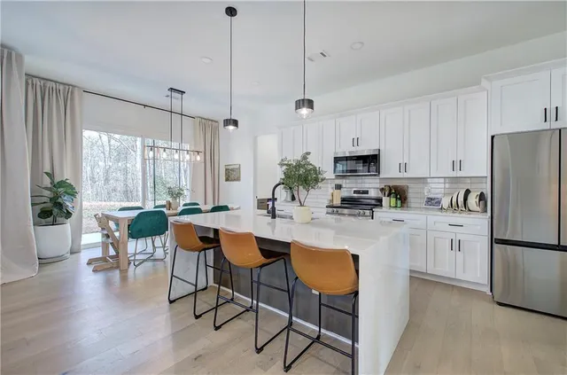 a kitchen with white cabinets and stainless steel appliances