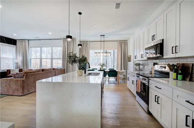 a kitchen with white cabinets and appliances