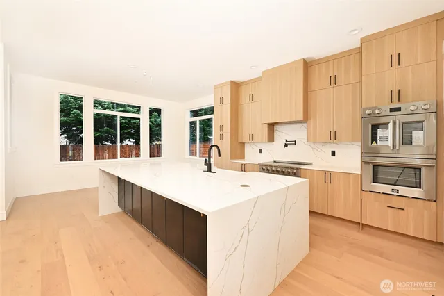 a large kitchen with stainless steel appliances kitchen island a large counter top and a stove