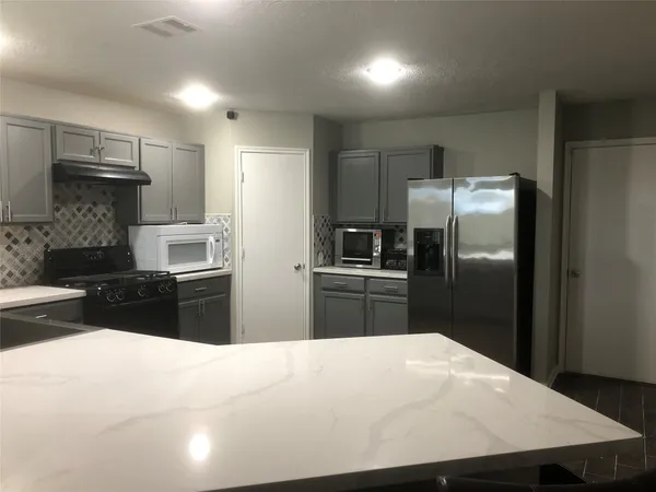 a kitchen with granite countertop a refrigerator and a sink