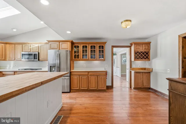 a open kitchen with stainless steel appliances granite countertop a stove and a wooden floors