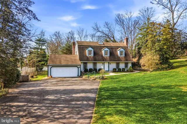 a view of a house with a big yard and large tree