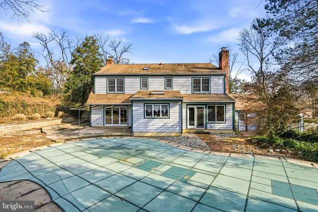 a view of a house with a big yard plants and large trees