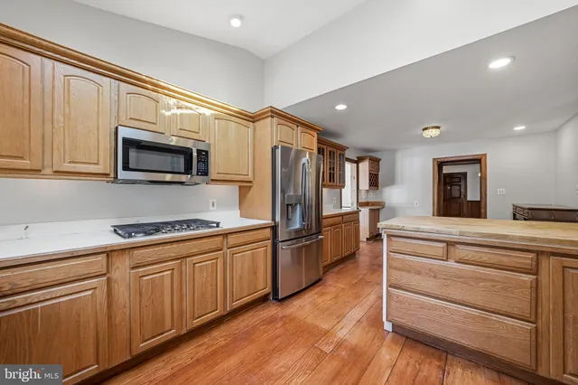 a kitchen with granite countertop a refrigerator and a stove top oven