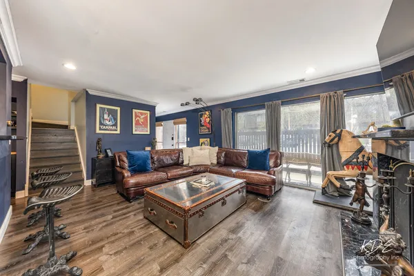 a living room with furniture a flat screen tv and a floor to ceiling window