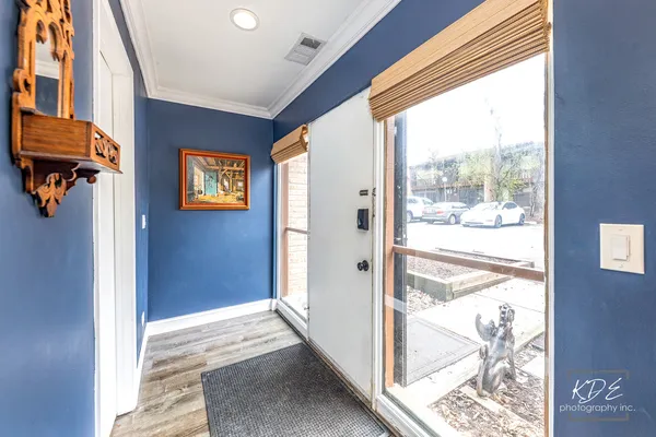 a view of a hallway with wooden floor and a dining room