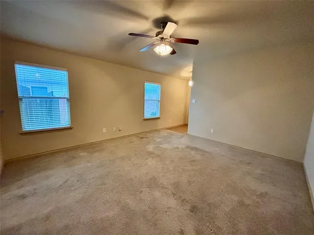 a view of an empty room with a ceiling fan