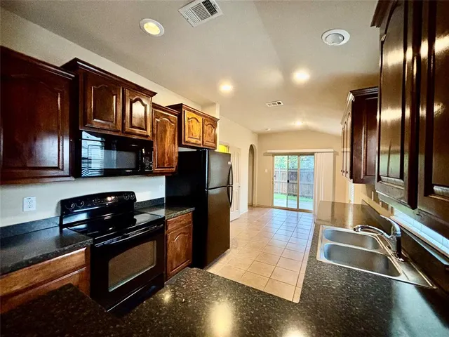 a kitchen with stainless steel appliances granite countertop a refrigerator and a stove