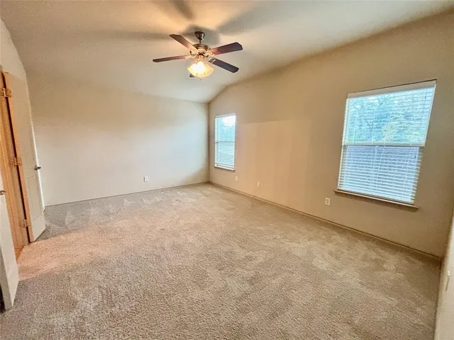 an empty room with windows and fan