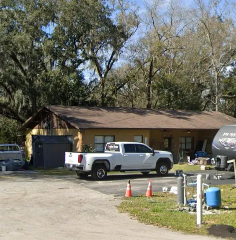 a front view of a house with cars parked